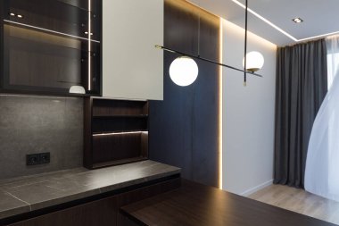 Geniş bir mutfak stüdyosunun iç tasarımı. Oturma odasında moda mobilyalar ve mutfak alanında modern detaylar..