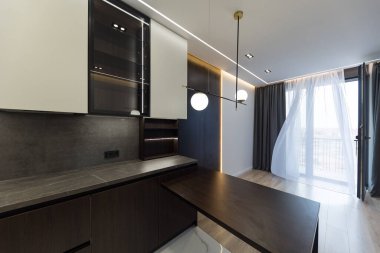 Geniş bir mutfak stüdyosunun iç tasarımı. Oturma odasında moda mobilyalar ve mutfak alanında modern detaylar..