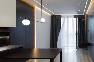 Geniş bir mutfak stüdyosunun iç tasarımı. Oturma odasında moda mobilyalar ve mutfak alanında modern detaylar..