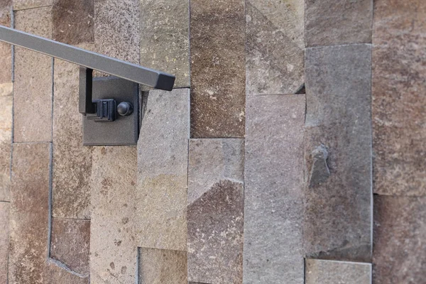 Evin yakınındaki taş duvara metal bir korkuluk dayadılar. Metal bir çit ve ızgara oruç tutmak. El yapımı. yüksek kaliteli fotoğraf. Yüksek kalite fotoğraf