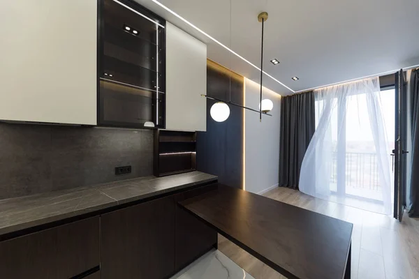 Geniş bir mutfak stüdyosunun iç tasarımı. Oturma odasında moda mobilyalar ve mutfak alanında modern detaylar..