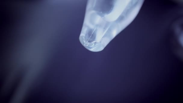 Disposable syringe is taking medicine from a glass ampoule, close up, dark background — Stock Video