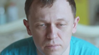 Gri gözlü üzgün bir gencin portresi, kameraya bakıyor, yakın plan.