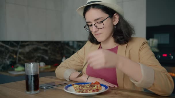 Ein Mädchen mit Hut, Essen und Surfen in einer mobilen App — Stockvideo