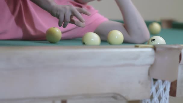 Young man playing with billiard balls while lying on billiard table, fun concept — Stock Video