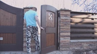 Avludan şapkalı bir adam çıkıyor.