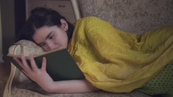 Portretul Unei Fete Drăguțe Care Citește Carte Întinsă Canapea — Videoclip de stoc