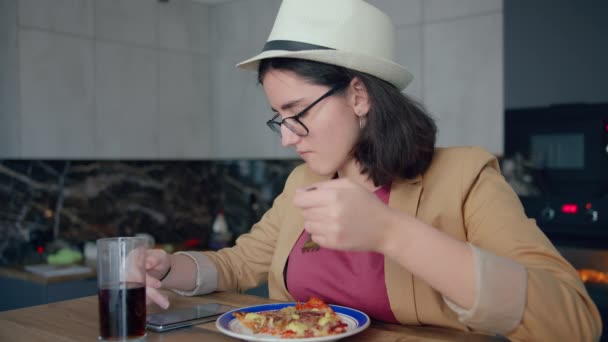 一个戴着帽子和眼镜的少女的肖像 吃着手机应用程序 浏览手机应用程序 — 图库视频影像