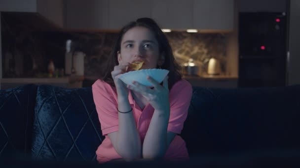 Menina Morena Comendo Batatas Fritas Assistindo Noite Sentada Casa Sofá — Vídeo de Stock