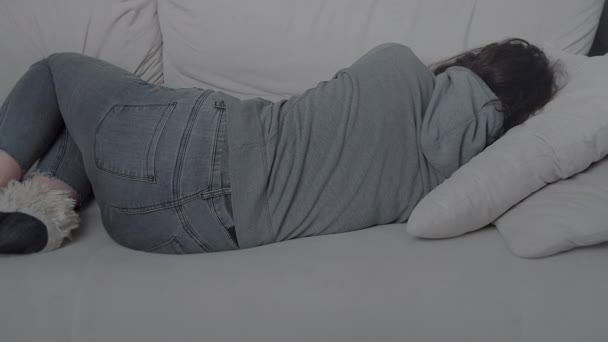 Mädchen liegt mit dem Rücken zur Wand auf dem Sofa, depressive Stimmung, Trennung und Verlust — Stockvideo