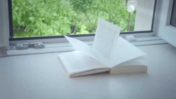 La ventana abierta en el alféizar de la ventana miente un libro, un día soleado — Vídeo de stock