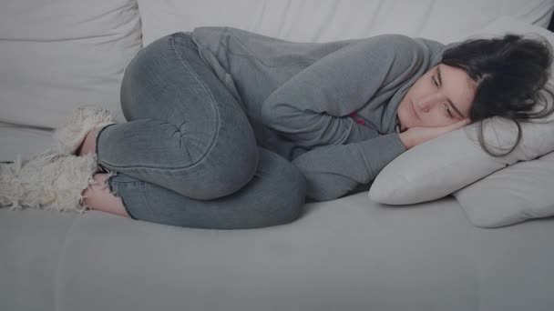 เด็กสาววัยรุ่นที่เหนื่อย นอนลงบนโซฟา แนวคิดการพักผ่อน — วีดีโอสต็อก
