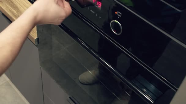 Mężczyzna wyciągający gorący arkusz pizzy domowej roboty z piekarnika, zbliżenie, śledzenie kamery — Wideo stockowe