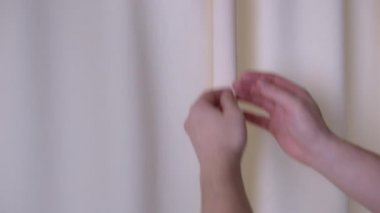 Erkekler pencerenin perdelerini açar, yakın plan.