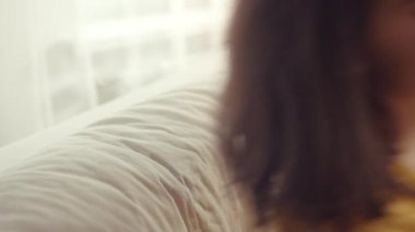 Hoş kız kanepede oturuyor, yüzünde rahat ve mutlu bir gülümseme, rahatlık bölgesi, yakın çekim.