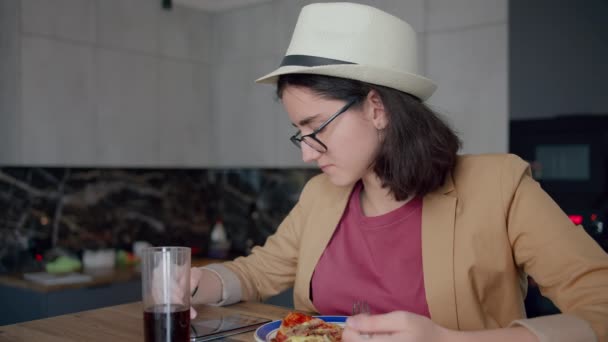Mädchen mit Hut und Brille, Essen und Surfen in einer mobilen App — Stockvideo