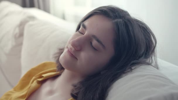 Nettes lächelndes brünettes Mädchen entspannt sich auf Sofa, Komfortzone — Stockvideo