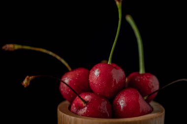 Koyu arkaplanda taze kirazlı dondurma aksiyon, sıçrama, su damlaları ve bokeh ile dinamik çekim. Yüzen taze meyve veya su damlası ve koyu arkaplan ile yükselen çekim.