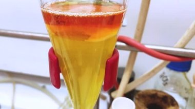 Eğitim amaçlı bir kimya laboratuvarında baca ayrımında organik katman ve su tabakasının ayrılması. Organik katmanlı karbondioksit kabarcığı. 4K bilimsel arkaplan kavramı.