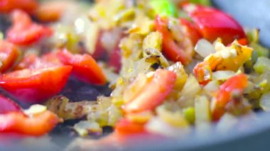 Arka planda 4K rengarenk buharlı sebzelerin tavada kızarması ve karıştırılması görüntüsü. Yemek pişirme, sağlıklı yemek, vejetaryen mutfağı. Lezzetli tat, ev yapımı yemek.