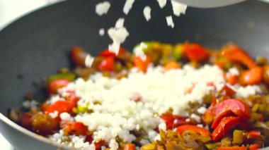 Arka planda 4K rengarenk buharlı sebzelerin tavada kızarması ve karıştırılması görüntüsü. Yemek pişirme, sağlıklı yemek, vejetaryen mutfağı. Lezzetli tat, ev yapımı yemek.