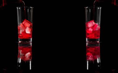 Buzun üstüne kırmızı alkollü kokteyl solüsyonu dökmek. Temiz bardağa, tamamen karanlık arka plana karşı. kopyalama alanı. İçki, şarap konsepti.