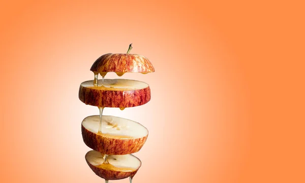 Frisch Geschnittener Roter Apfel Und Honig Tropfen Fliegende Nahrung Mit lizenzfreie Stockbilder