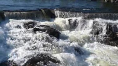 Akan suyu olan hidroelektrik baraj. Vahşi ormandaki peri şelalesi. Harika bir tatlı su şelalesi akıyor. Kükreyen bir deresi olan orman kayaları. 4K ve yavaş çekim.