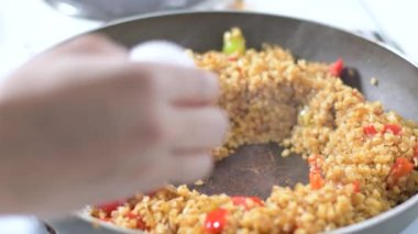 Arka planda 4K rengarenk buharlı sebzelerin tavada kızarması ve karıştırılması görüntüsü. Yemek pişirme, sağlıklı yemek, vejetaryen mutfağı. Lezzetli tat, ev yapımı yemek.