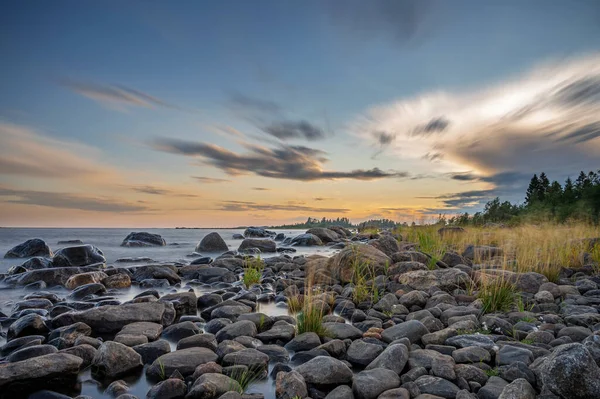 在海滨的石头旁边 长期暴露着华丽 色彩艳丽的落日 美丽的云彩飘扬与海滨石头 — 图库照片
