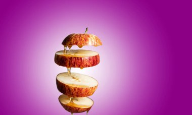 Taze dilimlenmiş kırmızı elma ve bal havada asılı duran yiyeceklere damlıyor. Alternatif şeker ikamesi, soğuk ilaç ve vücut güçlendirme, süper gıda kahvaltısı pembe arka plan.