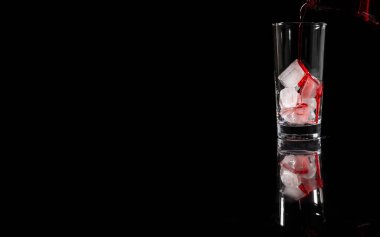 Buzun üstüne koyu arkaplana karşı kırmızı böğürtlen suyu dökülüyor. kopyalama alanı. İçki, şarap konsepti.