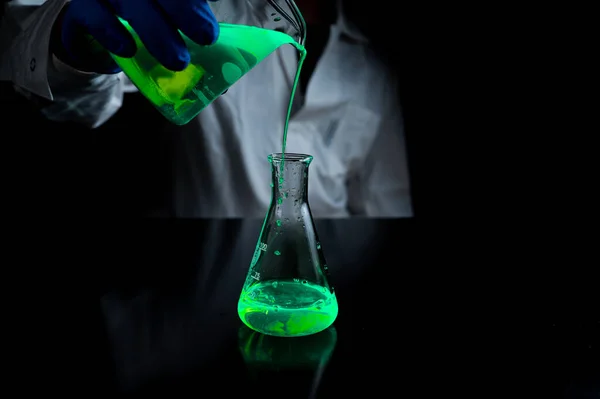 Женщина Ученый Экспериментирует Зеленым Флуоресцентным Раствором Стеклянной Конической Фляжке Лаборатории — стоковое фото