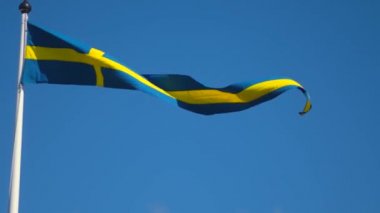 Swedish flags waving with the wind flow under the blue sky for national day celebration and symbol of european union. Swedish National day, midsummer. Slowmotion video with copyspace.
