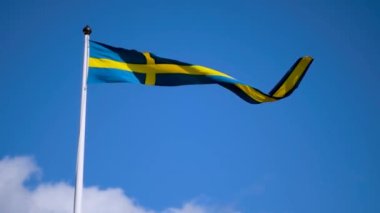 Swedish flags waving with the wind flow under the blue sky for national day celebration and symbol of european union. Swedish National day, midsummer. Slowmotion video with copyspace.