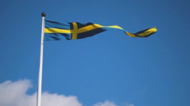 Swedish flags waving with the wind flow under the blue sky for national day celebration and symbol of european union. Swedish National day, midsummer. Slowmotion video with copyspace.