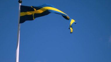 Swedish flags waving with the wind flow under the blue sky for national day celebration and symbol of european union. Swedish National day, midsummer. Slowmotion video with copyspace.