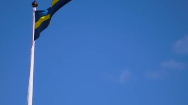 Swedish flags waving with the wind flow under the blue sky for national day celebration and symbol of european union. Swedish National day, midsummer. Slowmotion video with copyspace.