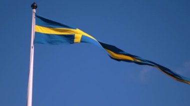Swedish flags waving with the wind flow under the blue sky for national day celebration and symbol of european union. Swedish National day, midsummer. Slowmotion video with copyspace.