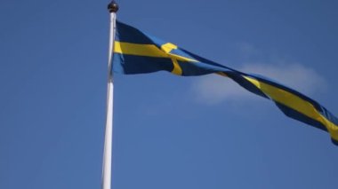 Swedish flags waving with the wind flow under the blue sky for national day celebration and symbol of european union. Swedish National day, midsummer. Slowmotion video with copyspace.
