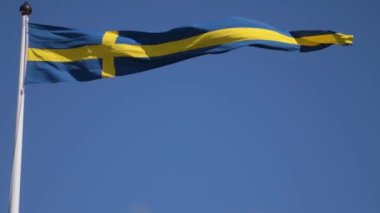 Swedish flags waving with the wind flow under the blue sky for national day celebration and symbol of european union. Swedish National day, midsummer. Slowmotion video with copyspace.