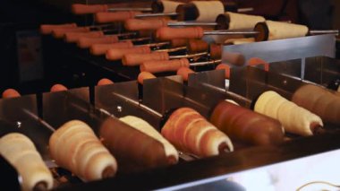 National Czech trdelnik sweet delicacy that is prepared on the street in 4K. Fresh baked Trdelnik with sugar and nuts in basket close-up. Traditional czech cuisine. Cooked national bohemian food.