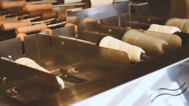 Ulusal Çek Trdelnik tatlısı 4K 'de sokakta hazırlanıyor. Taze pişmiş Trdelnik, sepetin içinde şeker ve fındık. Geleneksel Czech mutfağı. Ulusal bohem yemekleri pişirdim..