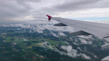 Uçak uçuşu. Bulutların üzerinde uçan bir uçağın kanatları. Gün batımı ve gündoğumu gökyüzü. Uçağın penceresinden bak. Uçak, uçak. Hava yoluyla seyahat etmek. 4K UHD video