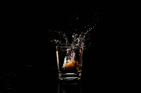 高分辨率自然水花冻结运动从一个干净的水杯与水滴和气泡形成 隔离在黑色背景 — 图库照片