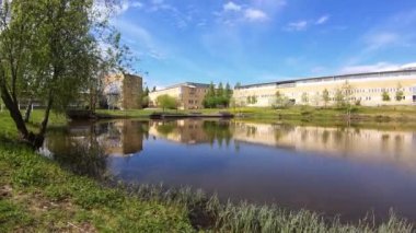 4K bulutlu zaman çizelgesi küçük bir gölün üzerindeki gündüz zamanı görüntüsü. Arkaplandan yansıma. 