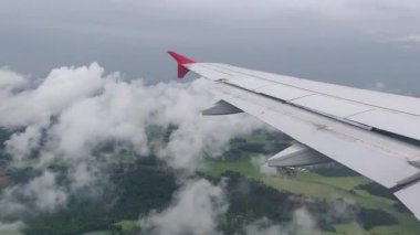 Uçak uçuşu. Bulutların üzerinde uçan bir uçağın kanatları. Gün batımı ve gündoğumu gökyüzü. Uçağın penceresinden bak. Uçak, uçak. Hava yoluyla seyahat etmek. 4K UHD video