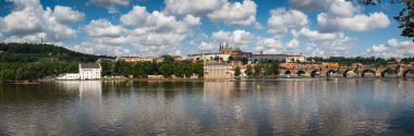 Panoramic view above at Charles Bridge Prague Castle and river Vltava Prague Czech Republic. Picturesque landscape with sunset old town houses with red tegular roofs and broach tower.