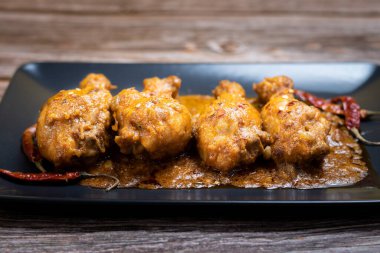 Hint usulü körili tavuk, Hint usulü körili, geleneksel hindistan cevizli ve siyah seramik bir kap içinde sıralanmış. Kopyalama arkaplanı, izole.