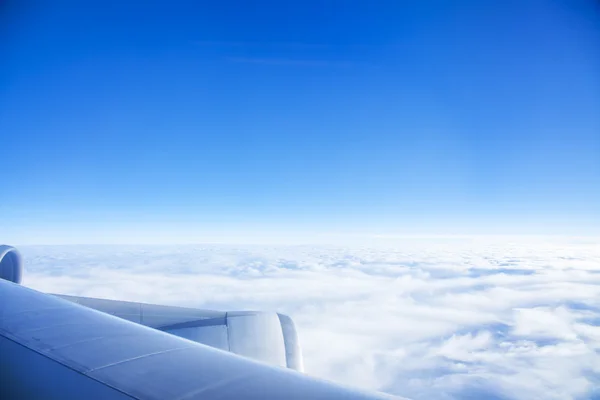 Looking through window aircraft during flight in wing with a blue sky — Stock Photo, Image